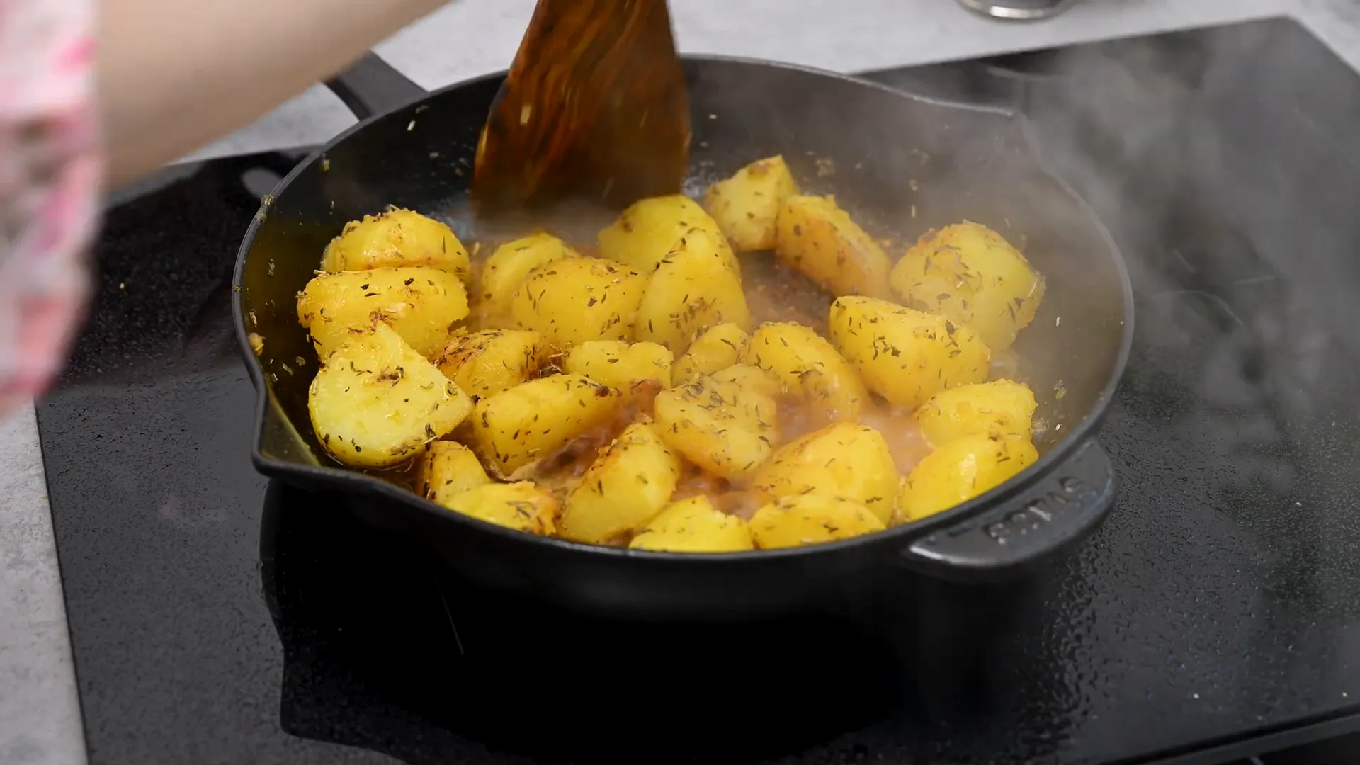 Pouring chicken stock into the skillet with potatoes